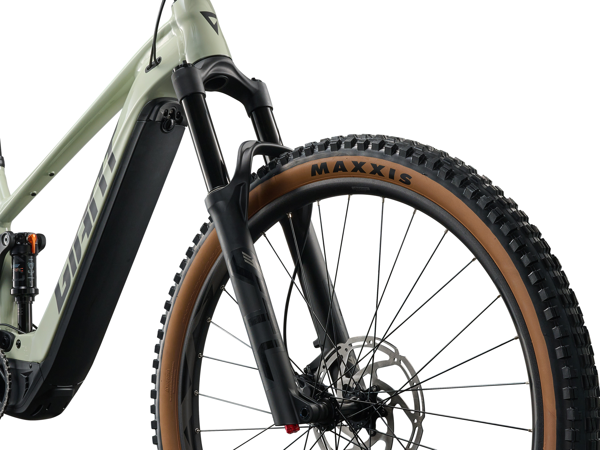 Giant Stance E+ 2 E‑MTB in Desert Sage mit Vorderrad, Maxxis‑Reifen und Federgabel.