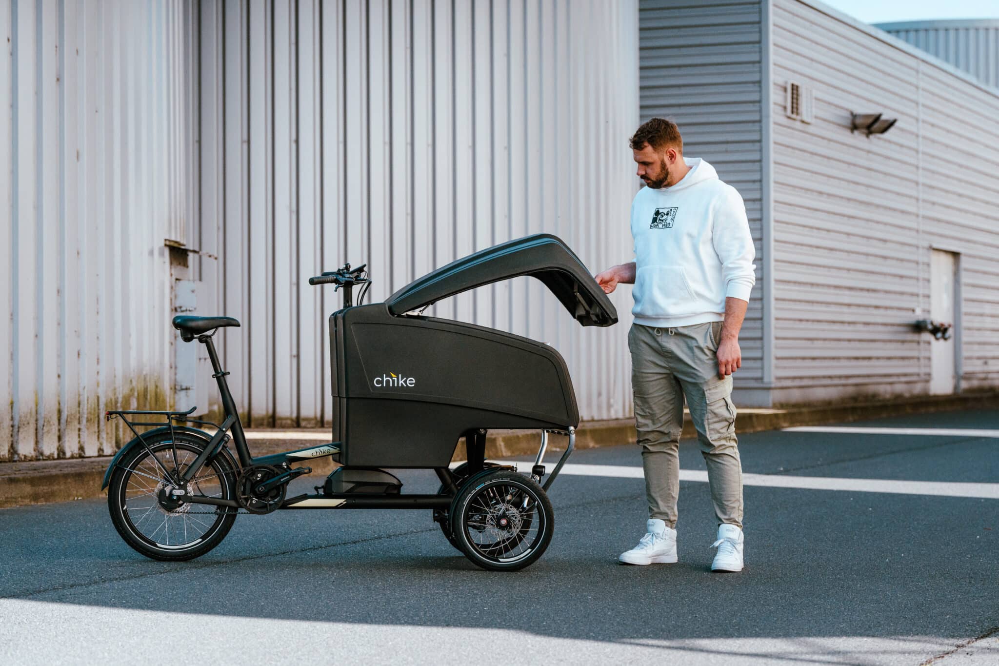 chike E‑Cargo Pro Lastenrad in Schwarz mit geoeffnetem Laderaum in Seitenansicht.