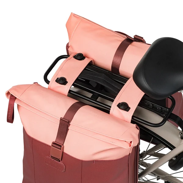 Nahaufnahme der montierten Basil Vive MIK Doppelpacktasche in Burgund/Pink mit Blick auf die obere Befestigung am Gepäckträger.