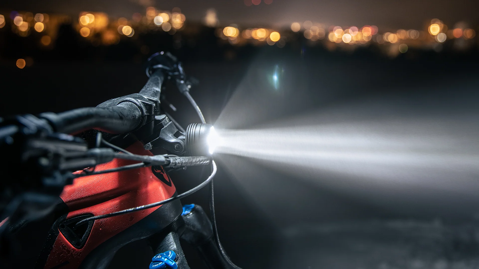 an einen Lenker montierter Supernova Mini2 pro Scheinwerfer mit hellem Lichtstrahl