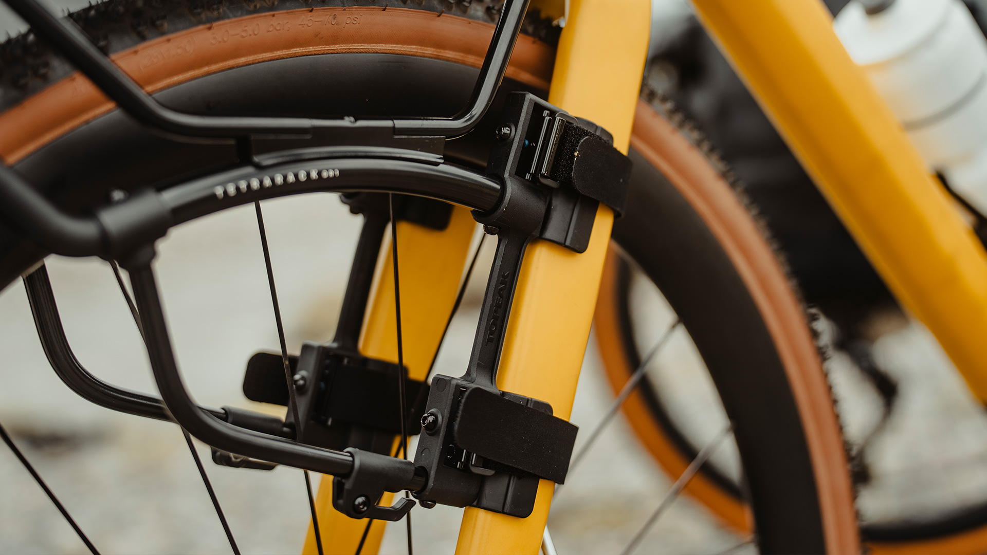 Sicht auf eine gelbe Gabel eines Gravelbike, an dem der Topeak TetraRack Gr1 mit Strapbändern befestigt ist.