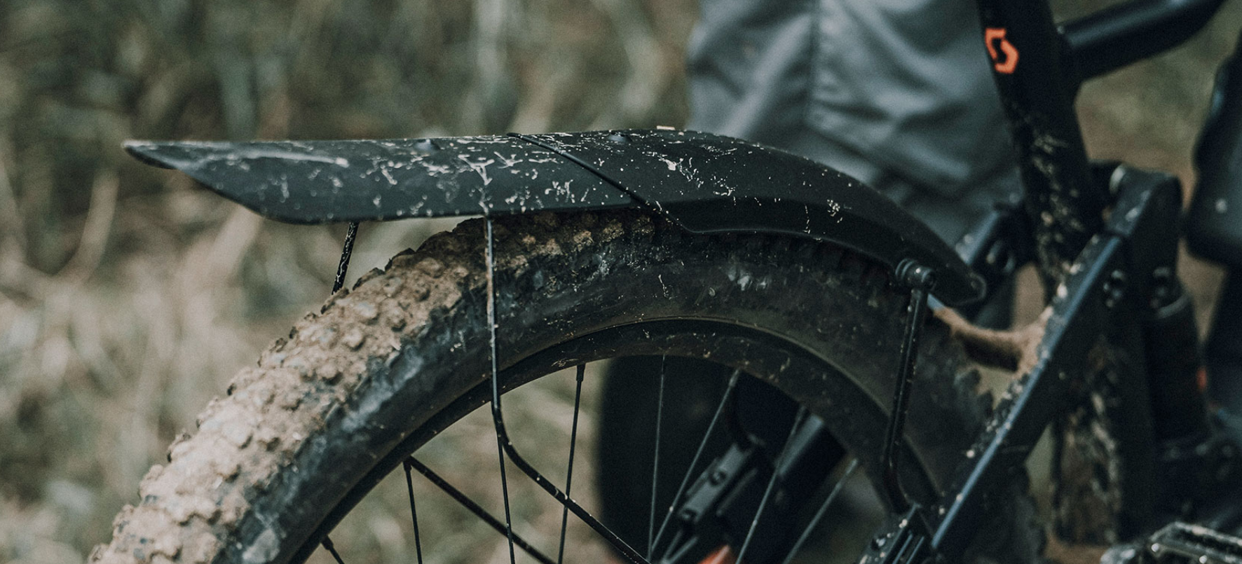 Hinterrad eines Mountainbikes mit montiertem Topeak TetraFender M2 Schutzblech, stark verschmutzter Reifen nach Offroad-Fahrt.