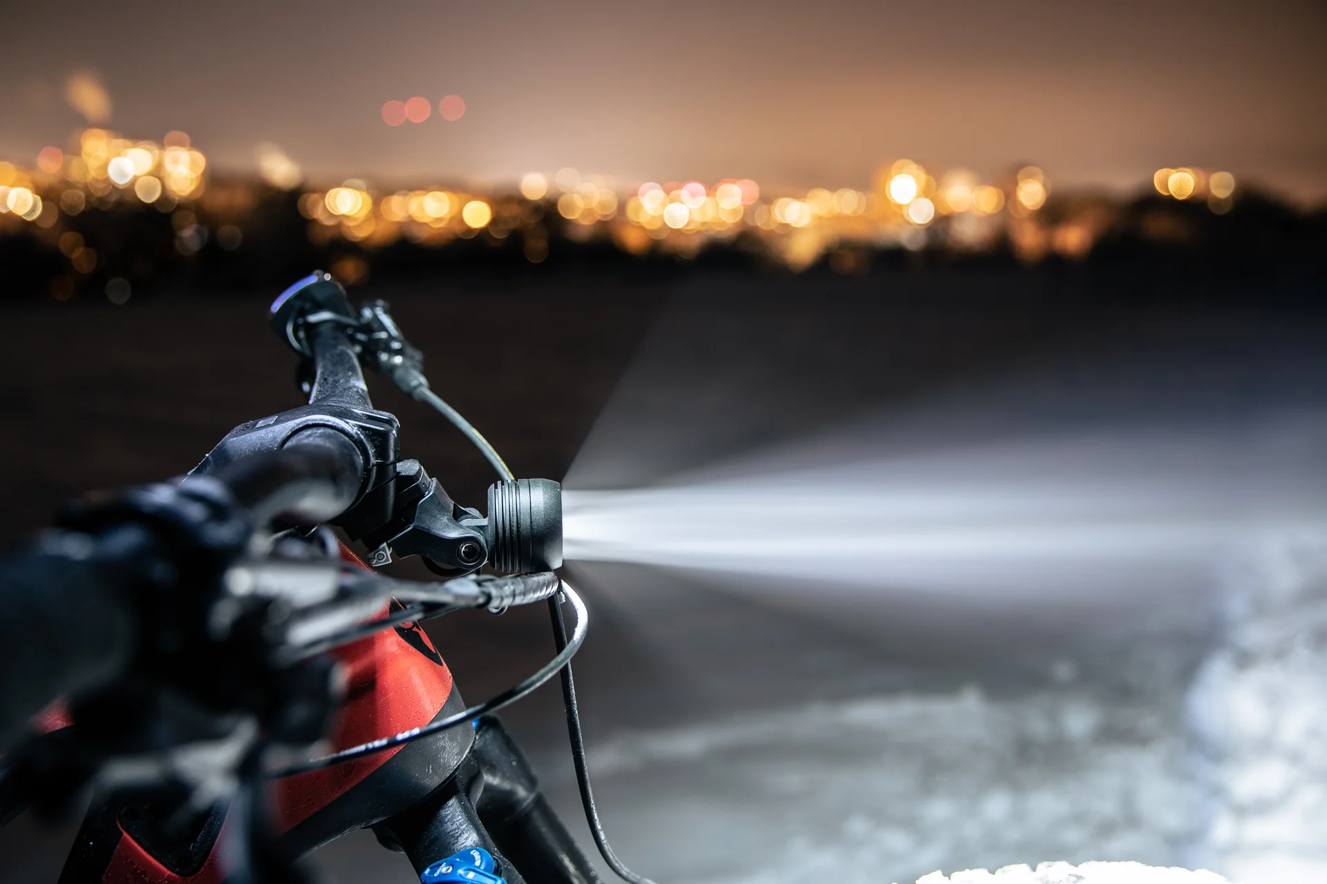 Am Vorbau montierter Supernova Mini 3 Pro Scheinwerfer mit hellem Lichtstrahl im Dunkeln