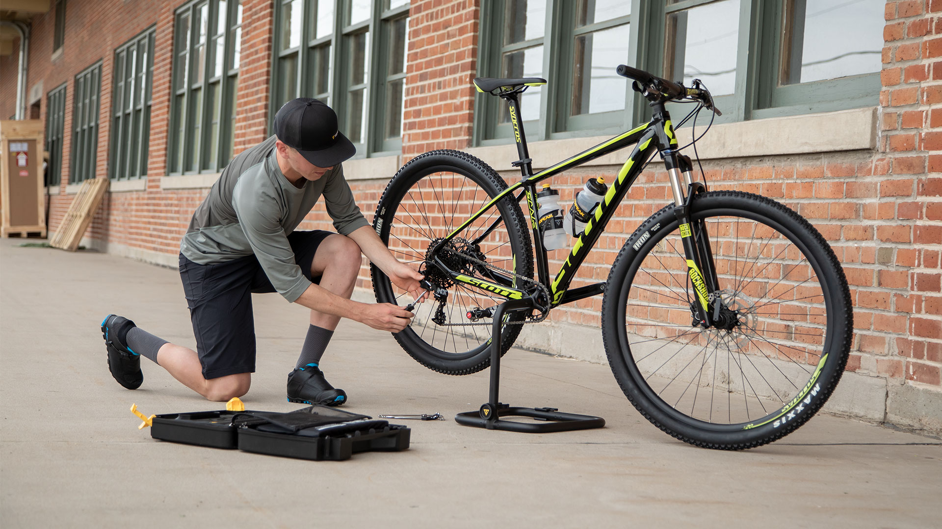Topeak Flashstand MX Fahrradständer mit Mann, der am Velo schraubt